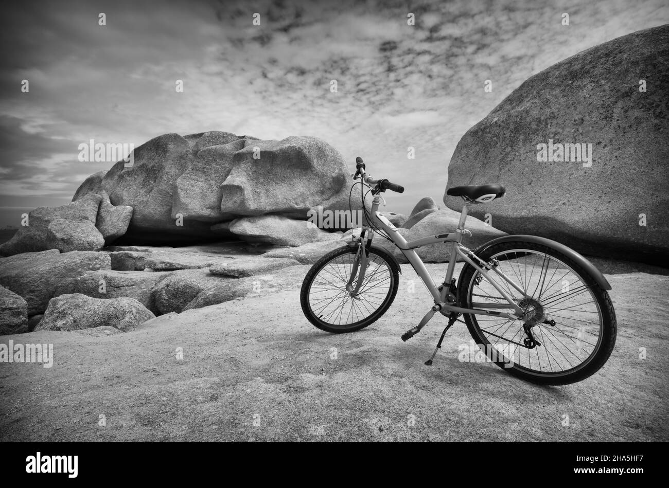 parked mountain bike in front of felsformatiionem,ãžle renote,rocky coast along the sentier des douaniers,trégastel,côte de granit rose,cotes d'armor,brittany,france Stock Photo
