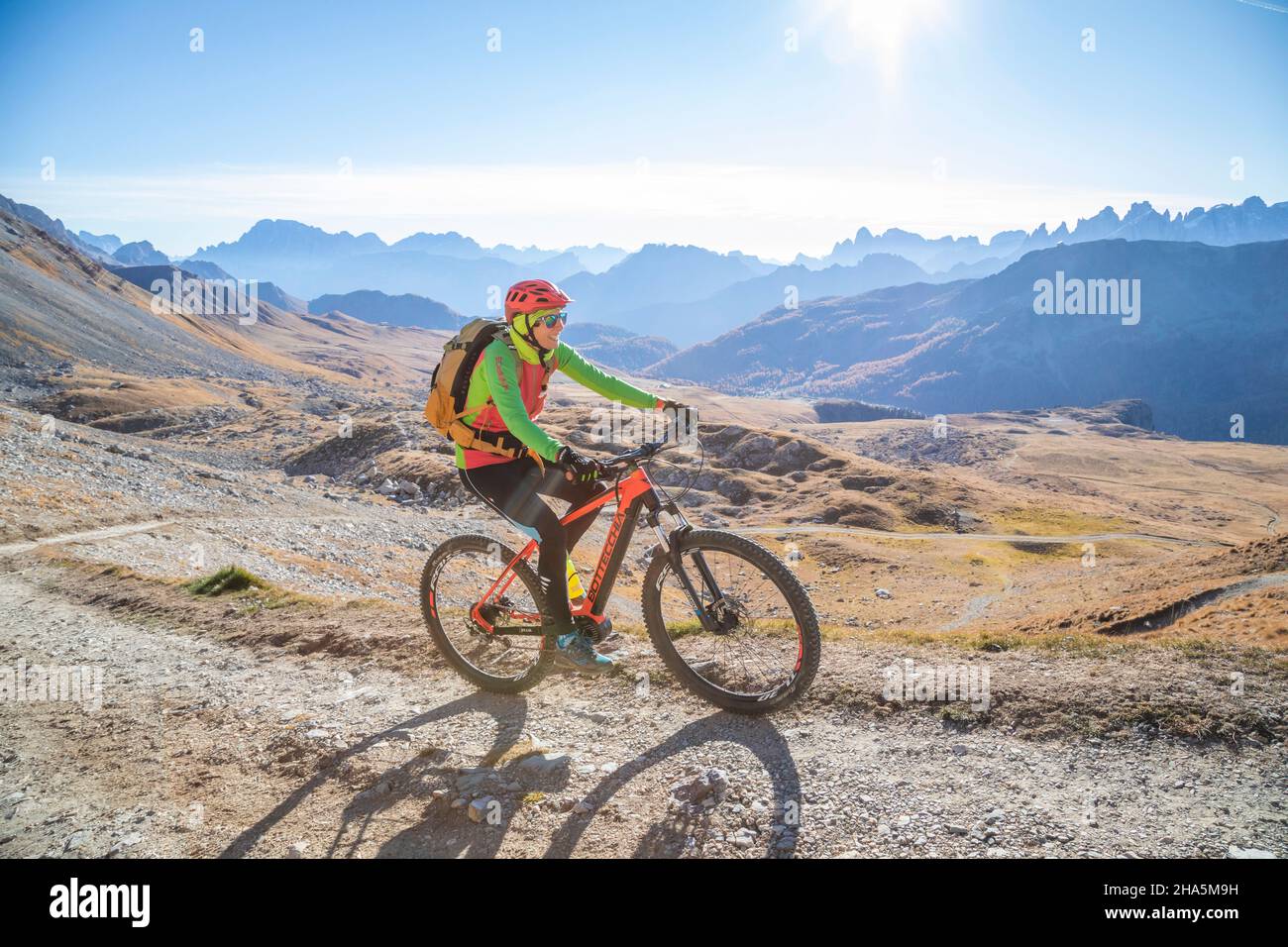 woman cyclist riding an e-bike in the area around the san pellegrino pass,dolomites,municipality of moena,trento,trentino alto adige Stock Photo