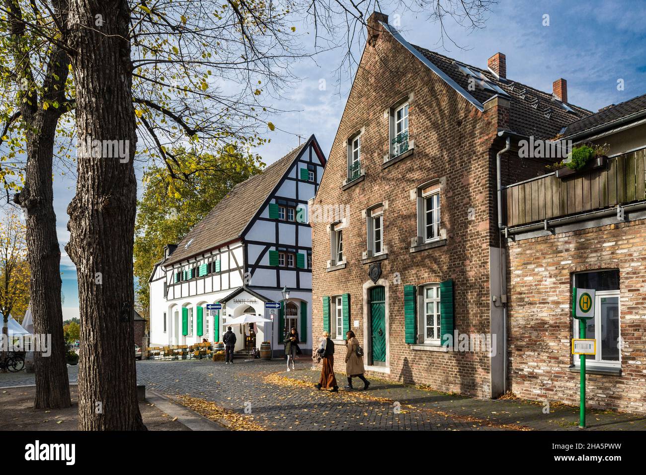 germany,monheim am rhein,bergisches land,niederbergisches land,niederberg,rhineland,north rhine-westphalia,north rhine-westphalia,old town hall in the old town,formerly an inn,brick building,on the left the tante tina restaurant,half-timbered house with green shutters,trees with autumn colors Stock Photo