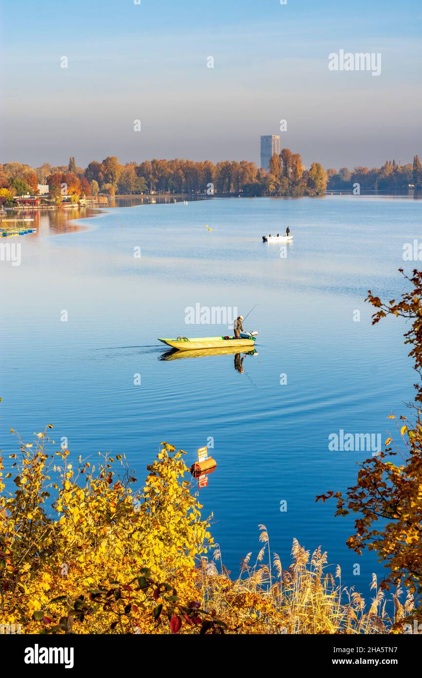 vienna,oxbow lake alte donau (old danube),high-rise vienna twenty two,boat with angler,autumn colors in 22. donaustadt,vienna,austria Stock Photo