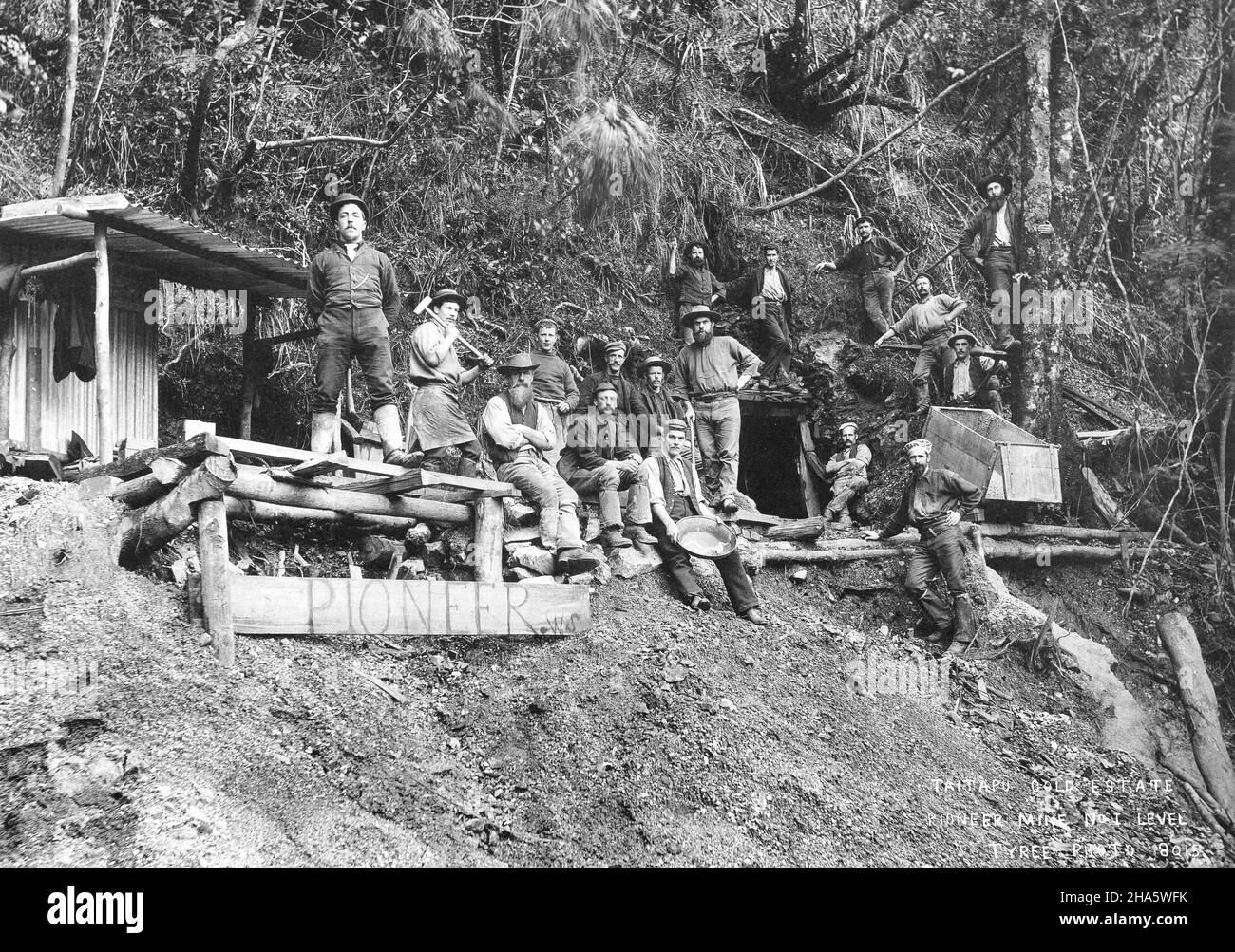 A group of 17 miners at the Pionerr Gold Mine at the Tai Tapu Gold Estate near Golden Bay, New Zealand, circa 1895. A corrugated iron shelter is at left. Stock Photo