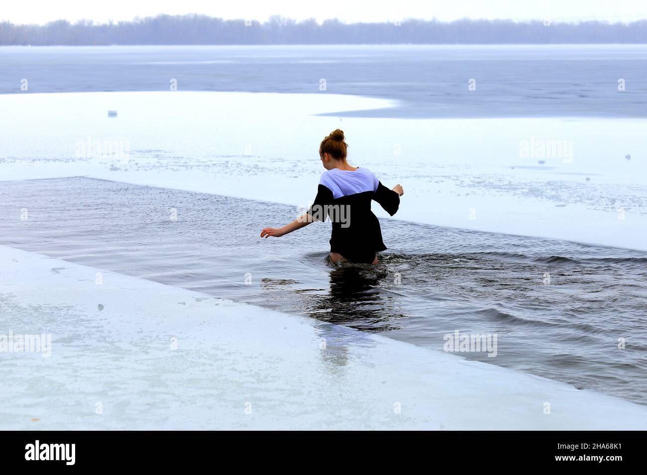 Winter swimming. Hardening. A woman swims in a winter ice-covered river during the Orthodox feast of the Epiphany. Dnipro, Dnipropetrovsk, Ukraine Stock Photo