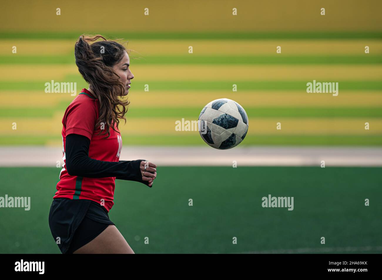 Young female soccer player kicks the ball on the field Stock Photo Alamy
