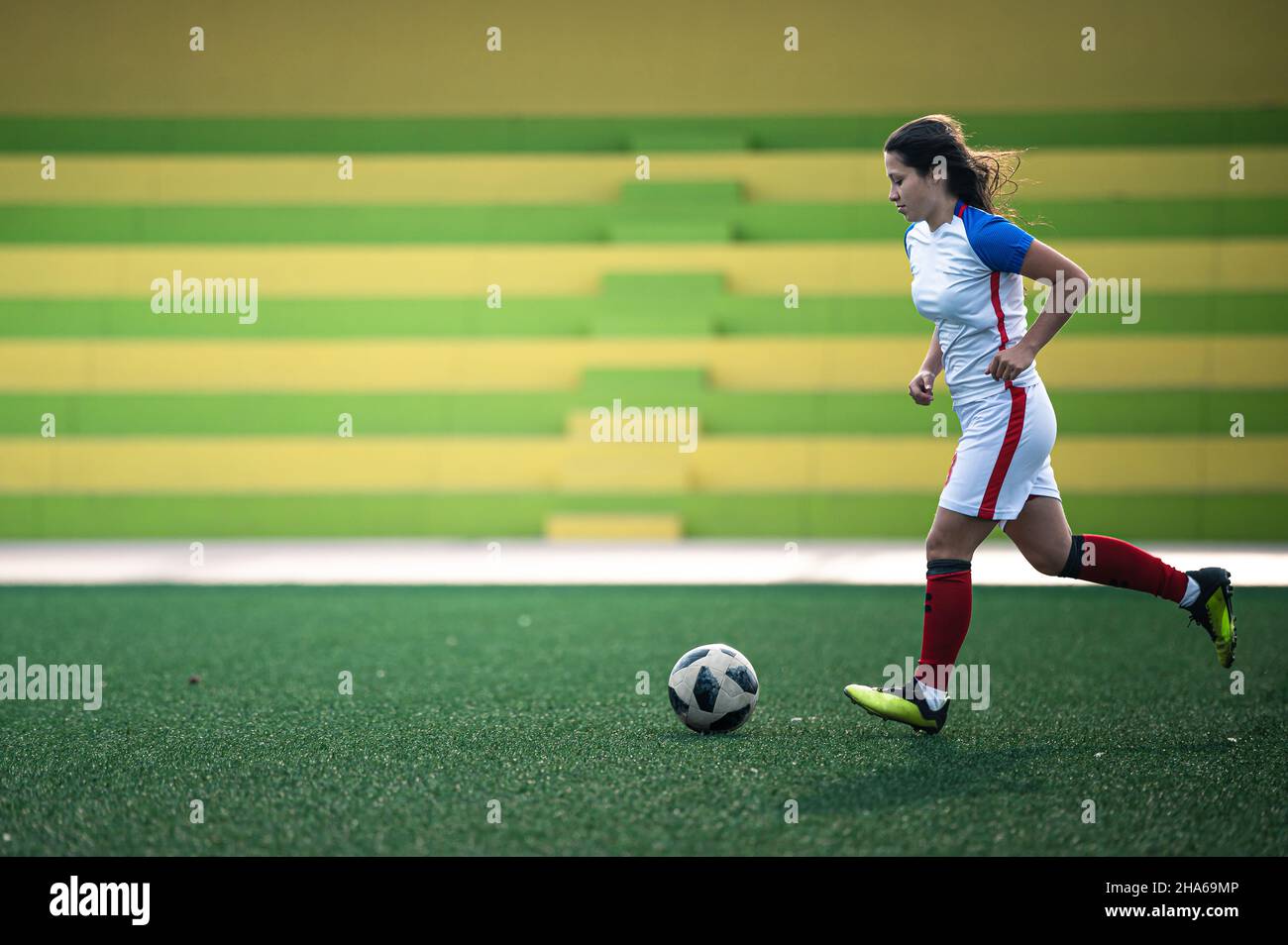 young female soccer player kicks the ball on the field Stock Photo Alamy