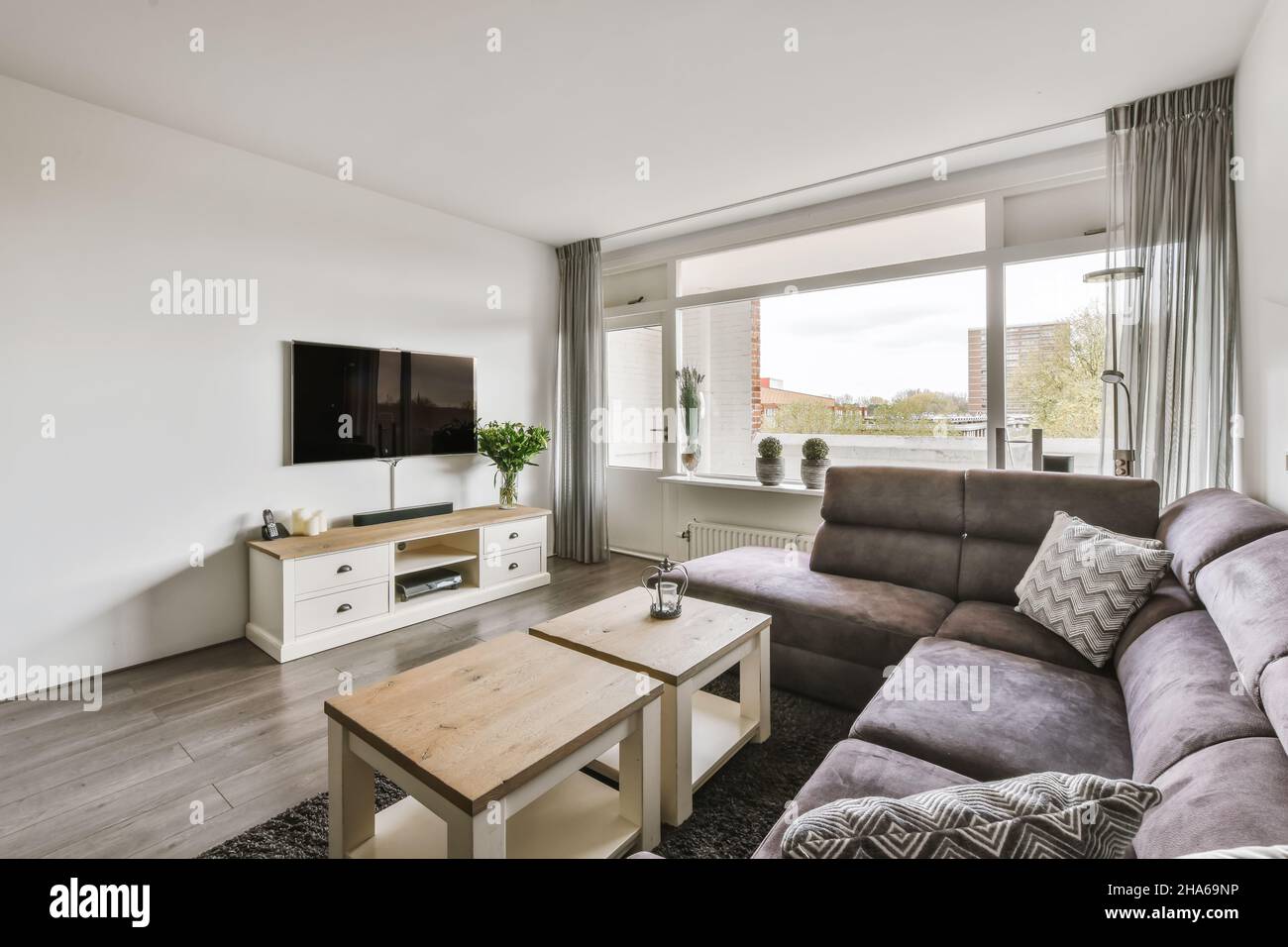 Stylish living room with soft sofa and plasma TV Stock Photo