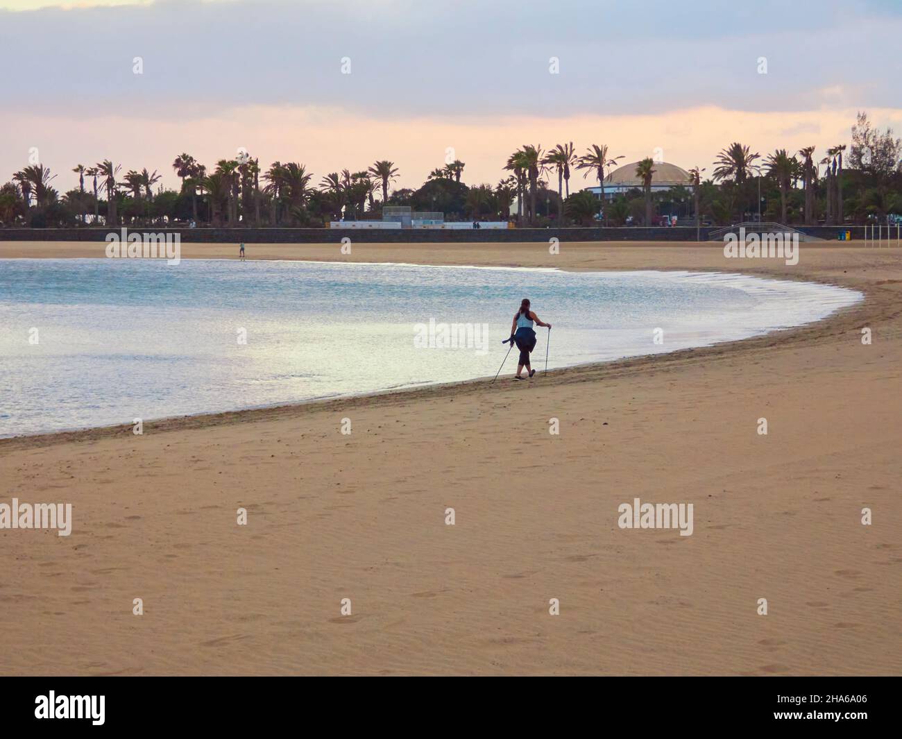 Person walking on the beach with sunset light Stock Photo