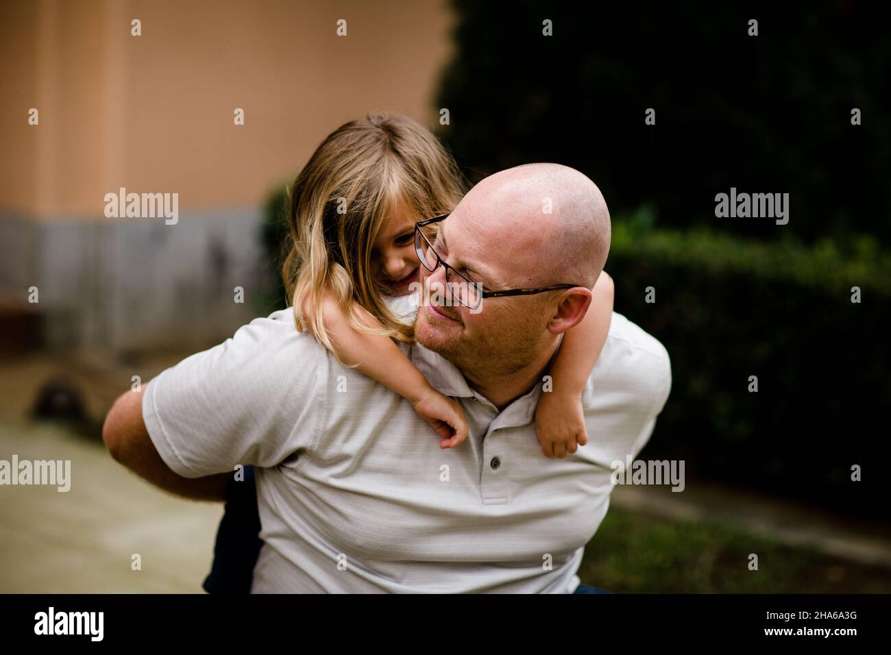 Four Year Old Climbing on Dad's Back in San Diego Stock Photo