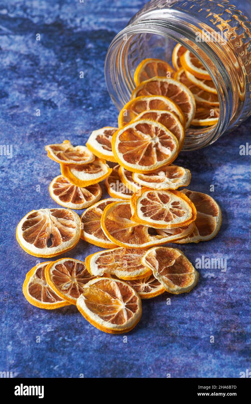 Dried Orange Slices Falling Inside From a Jar. Dried Fruit Concept Stock Photo