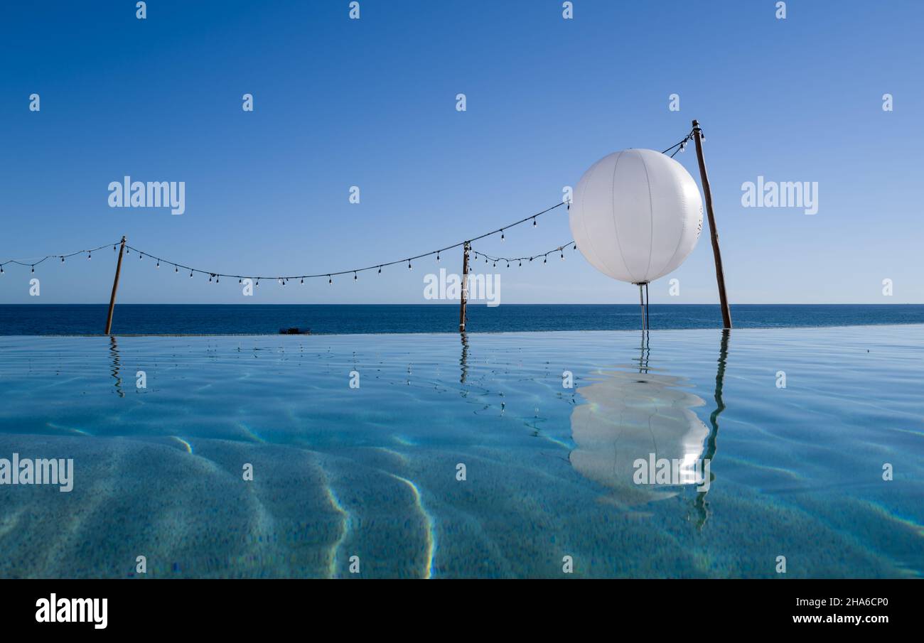 Large white balloon reflection in the calm summer pool along the ocean beach Stock Photo
