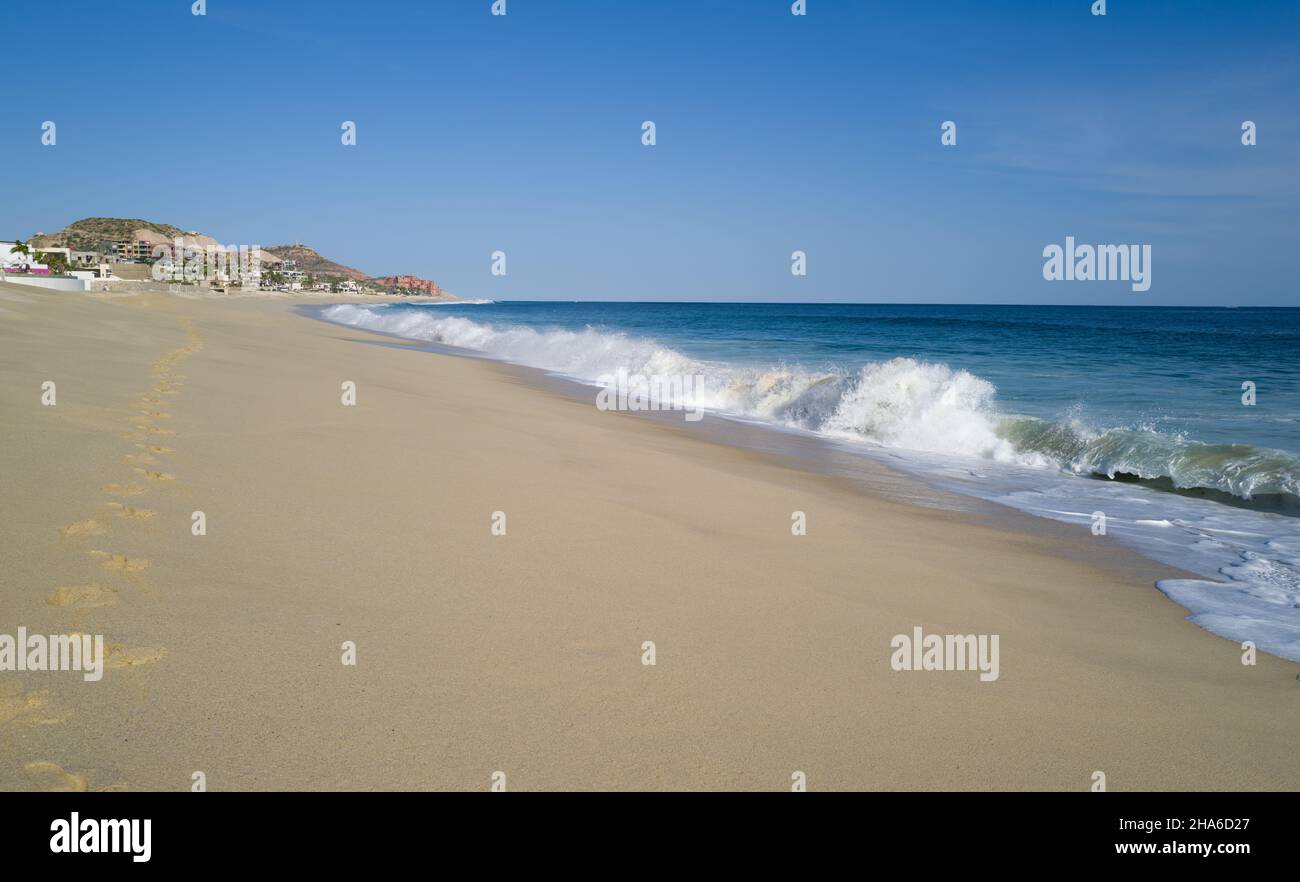 Ocean waves crashing on the beach under blue sky Stock Photo - Alamy
