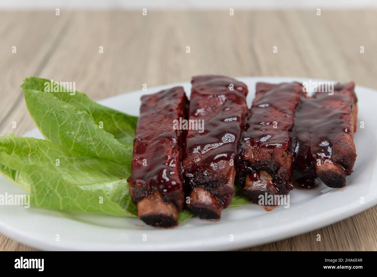 Barbecue ribs glazed with sauce and garnished with lettuce for you to eat. Stock Photo