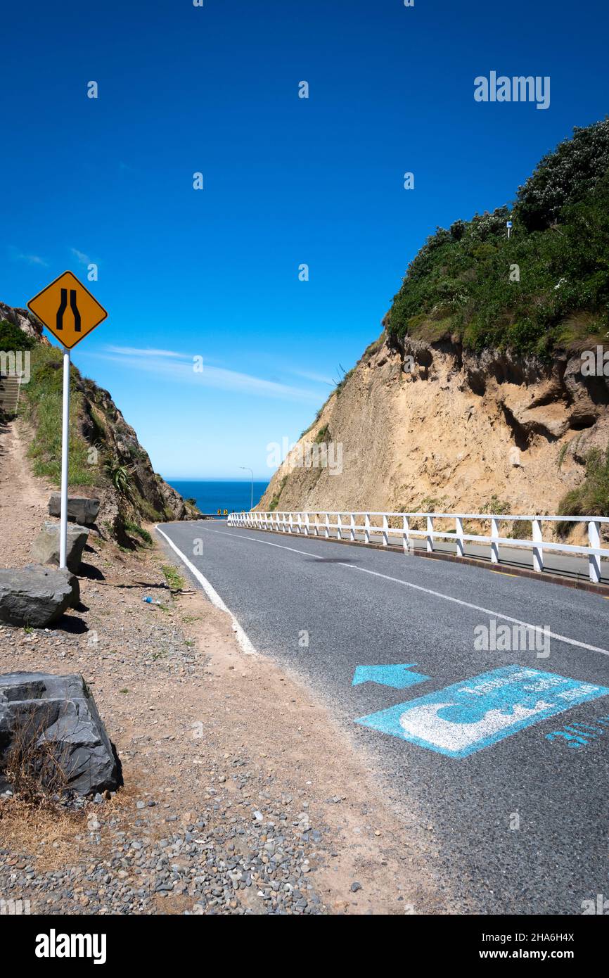 Narrow road through cutting to sea, Pass of Branda, Seatoun, Wellington, North Island, New Zealand Stock Photo