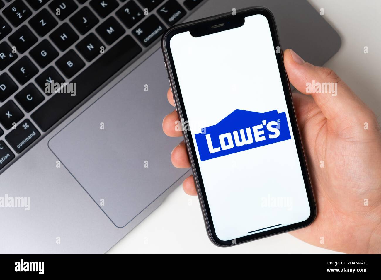 Lowes the application is open in the smartphone. The man is holding a mobile phone in his hand, the company application is open on the screen. Secure online shopping. November 2021, San Francisco, USA Stock Photo