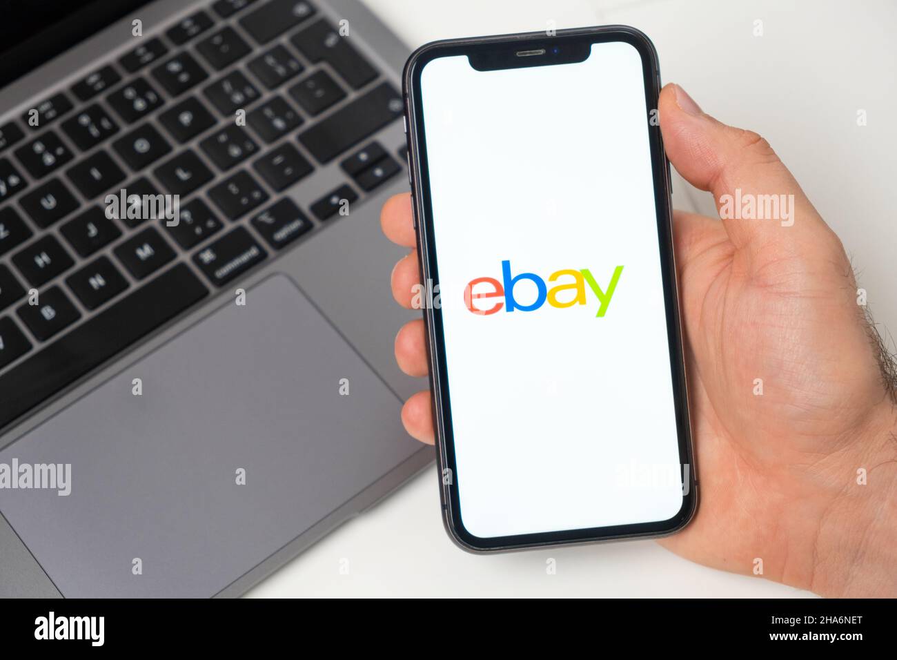 Ebay the application is open in the smartphone. The man is holding a mobile phone in his hand, the company application is open on the screen. Secure online shopping. November 2021, San Francisco, USA Stock Photo