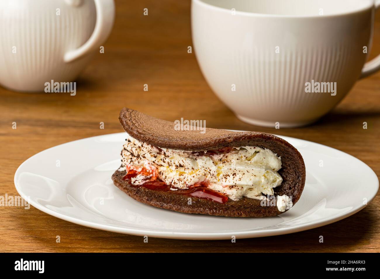 Delicious breakfast with Mini Black Forest Pancake with white fresh cream in white ceramic plate and a cup of coffee. Stock Photo