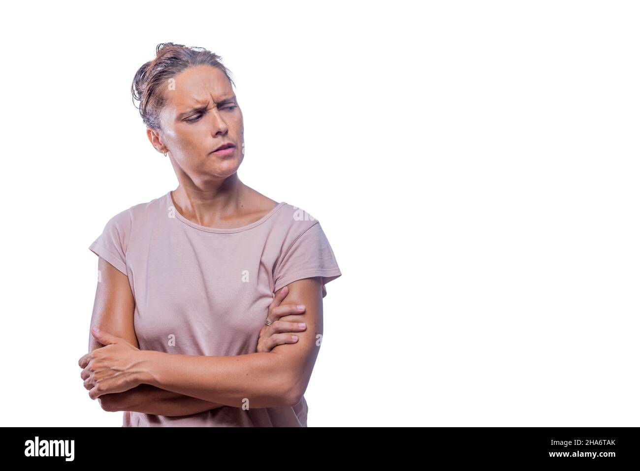 distrustful woman with crossed arms looking to a side Stock Photo