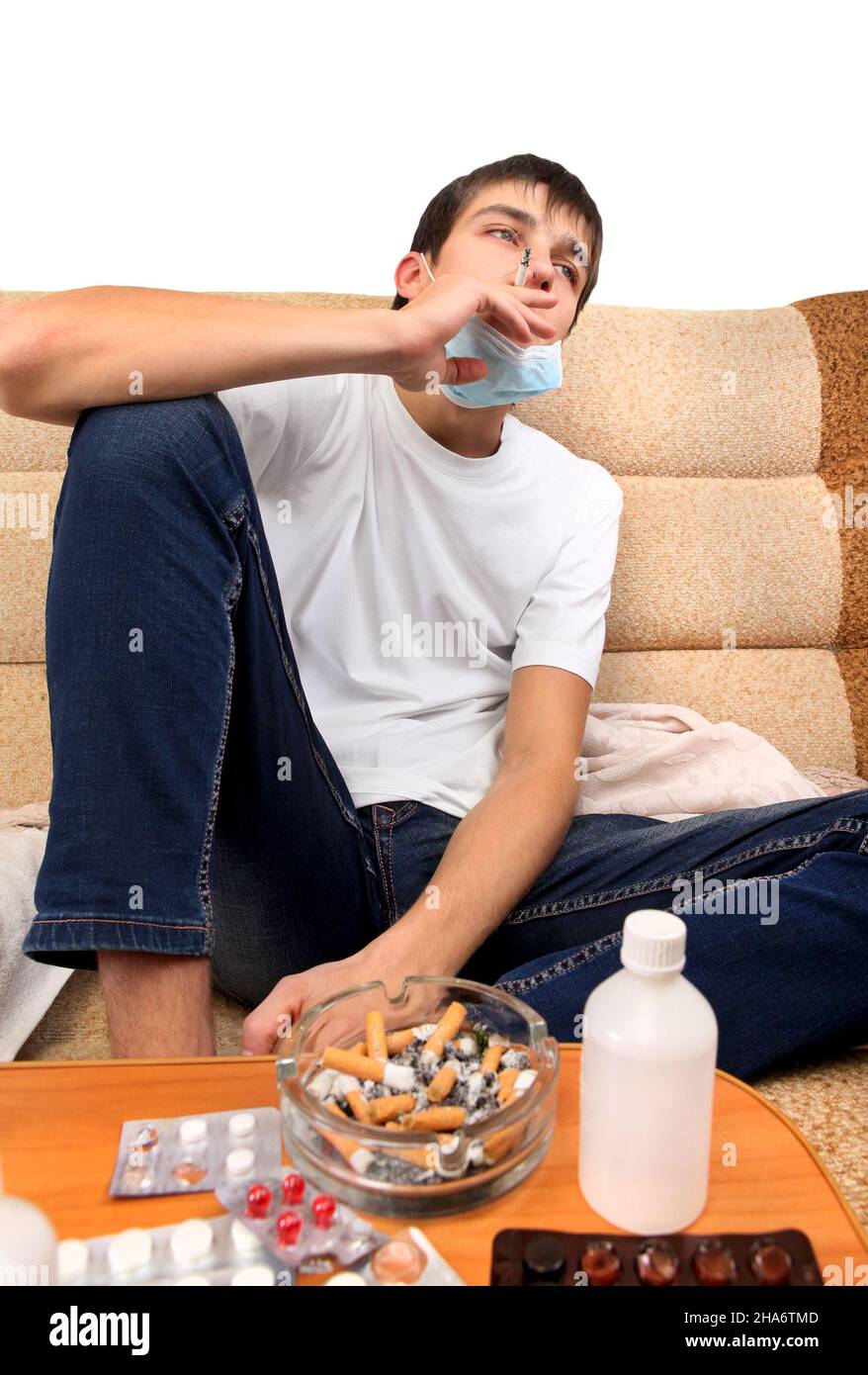 Sick Teenager smoking Cigarette on the Sofa with the Pills on