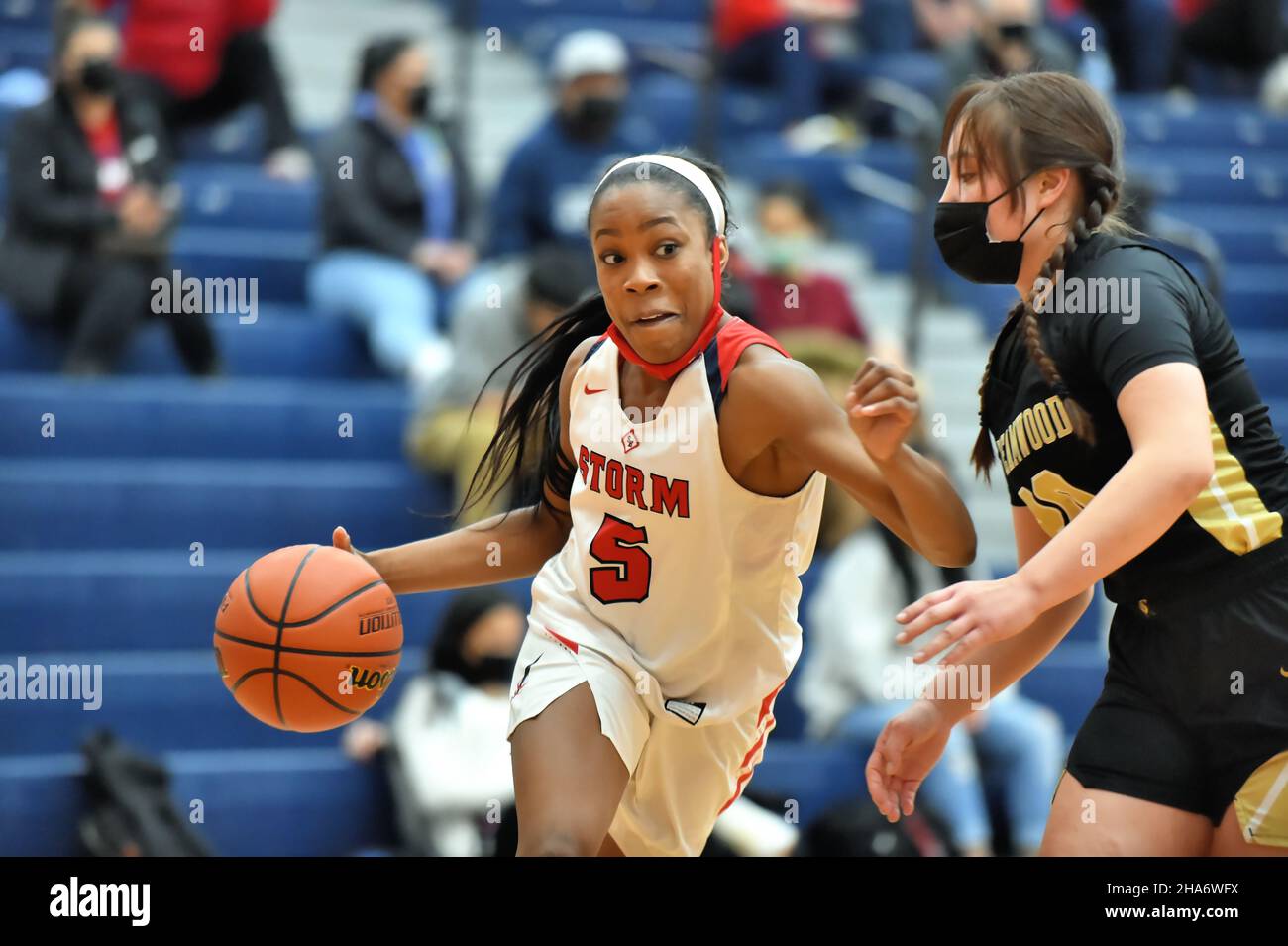 USA. High school guard dribbling along the baseline during a drive on the basket. Stock Photo