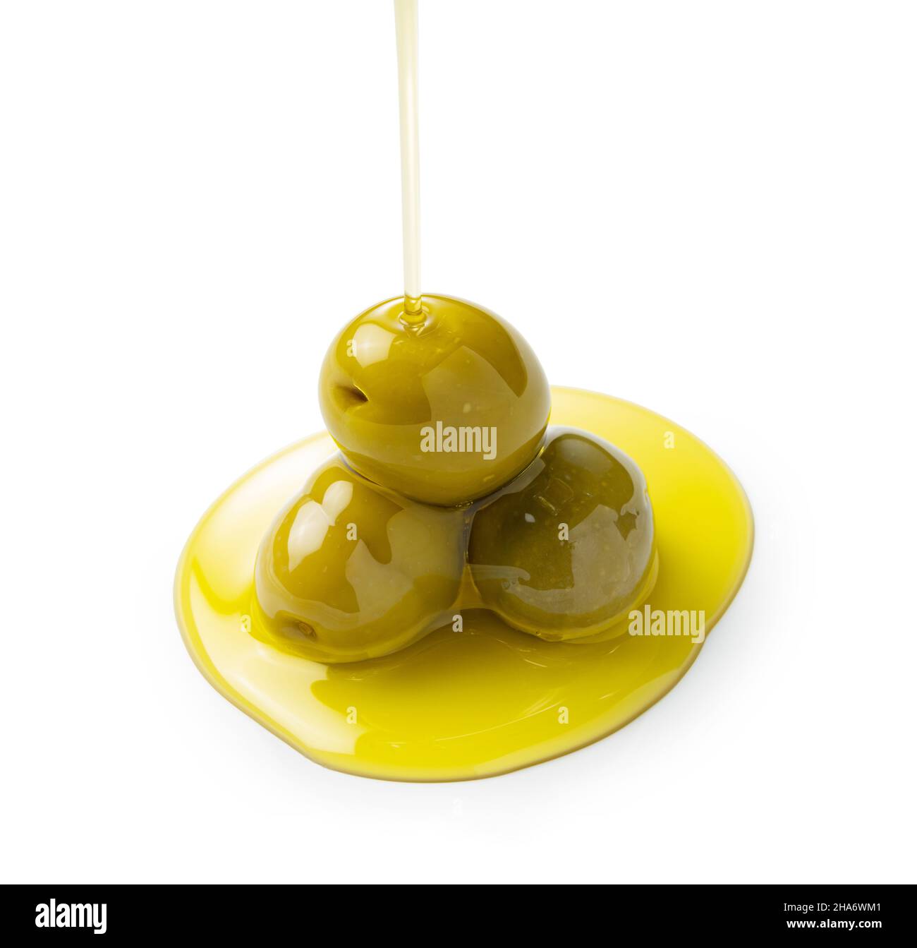 The moment when olive oil is poured over olives placed on a white background Stock Photo