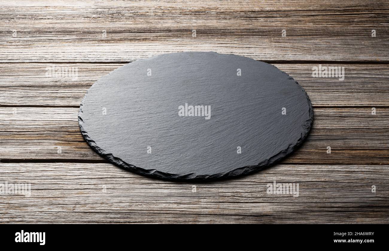 Stone plate placed on a wooden background, concept for composition Stock Photo