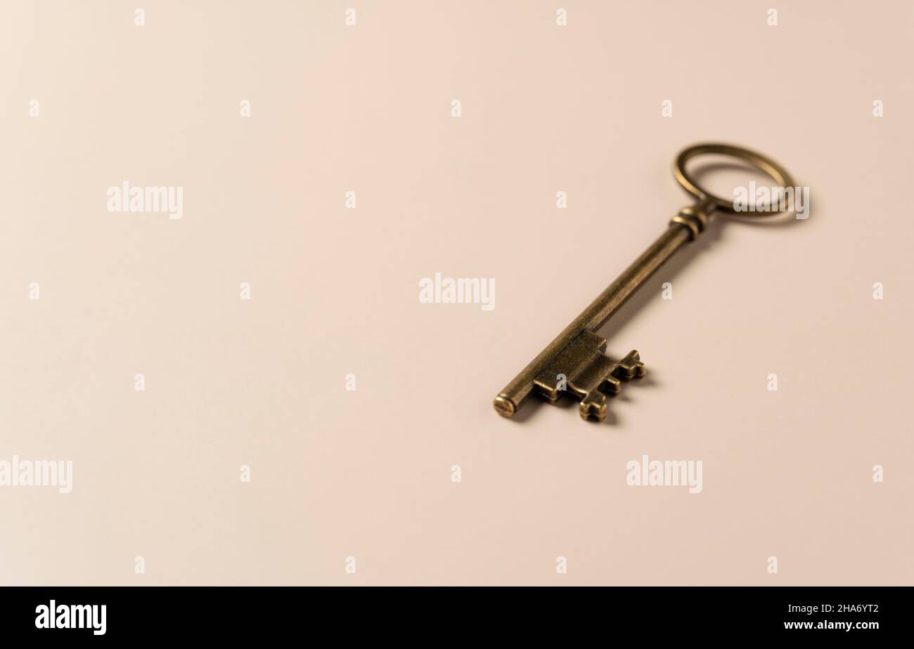 Retro brass keys on a beige background with copy space. Stock Photo