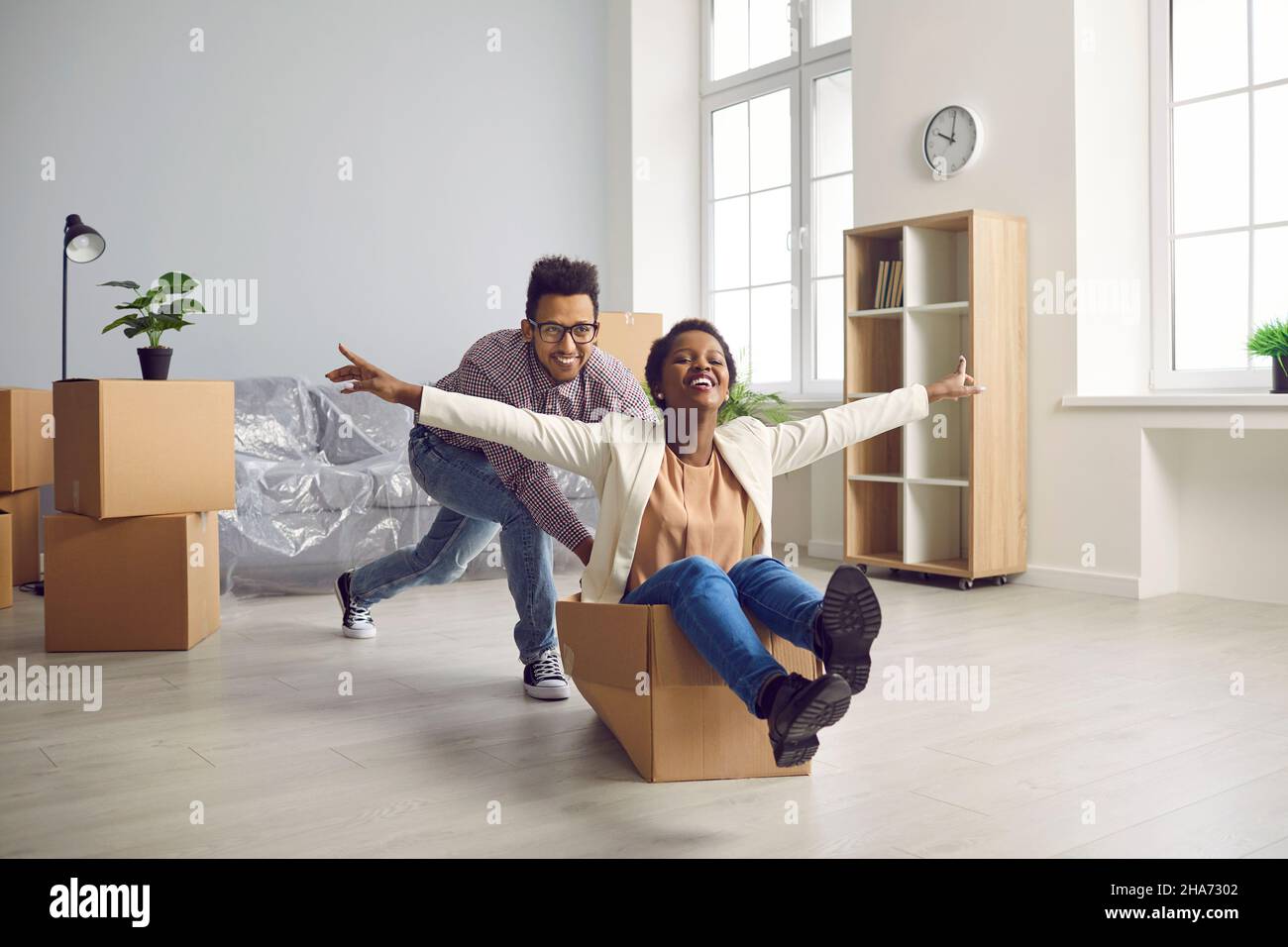Cheerful young couple moving into their first own home having fun and rejoicing. Stock Photo