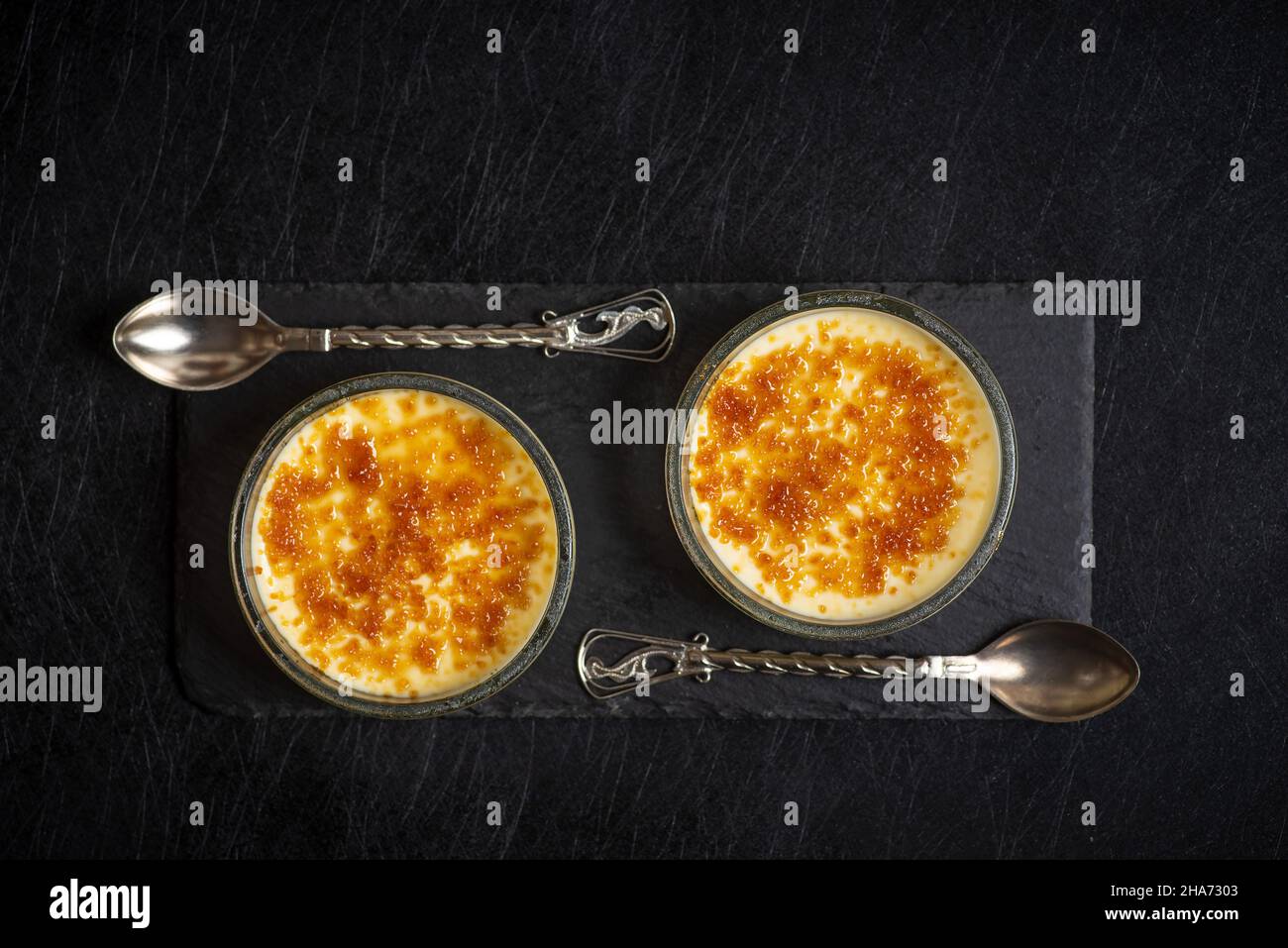 French vanilla cream desert with cinnamon in a bowl top view on dark table Stock Photo