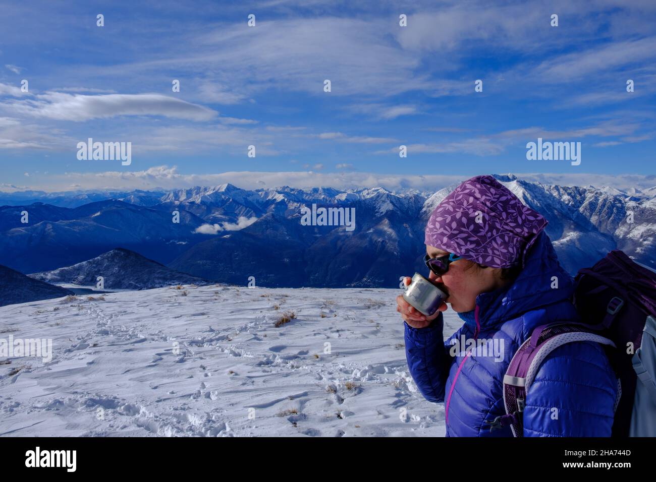 Woman having a hot drink on a snow covered landscape Stock Photo