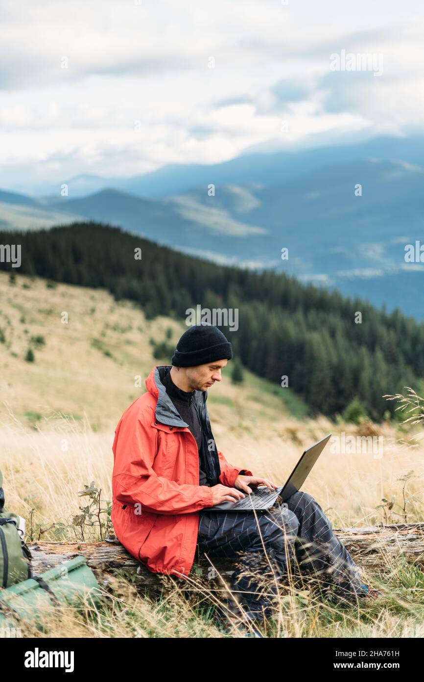 tourist freelancer in the mountains working online, laptop in travel for work, internet technologies for tourism, freelance concept Stock Photo