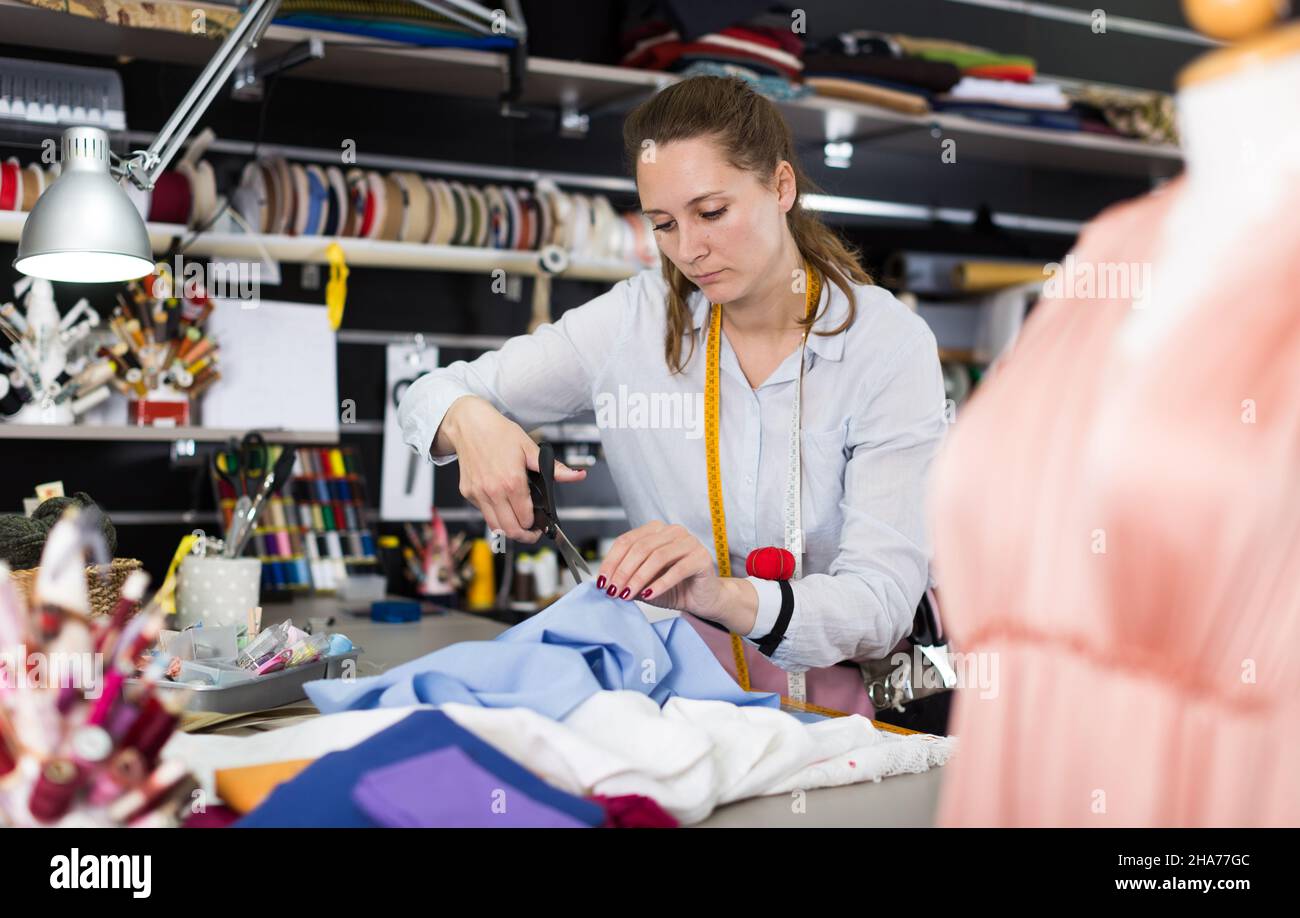 Portrait of woman designer who is doing new pattern for dress in the