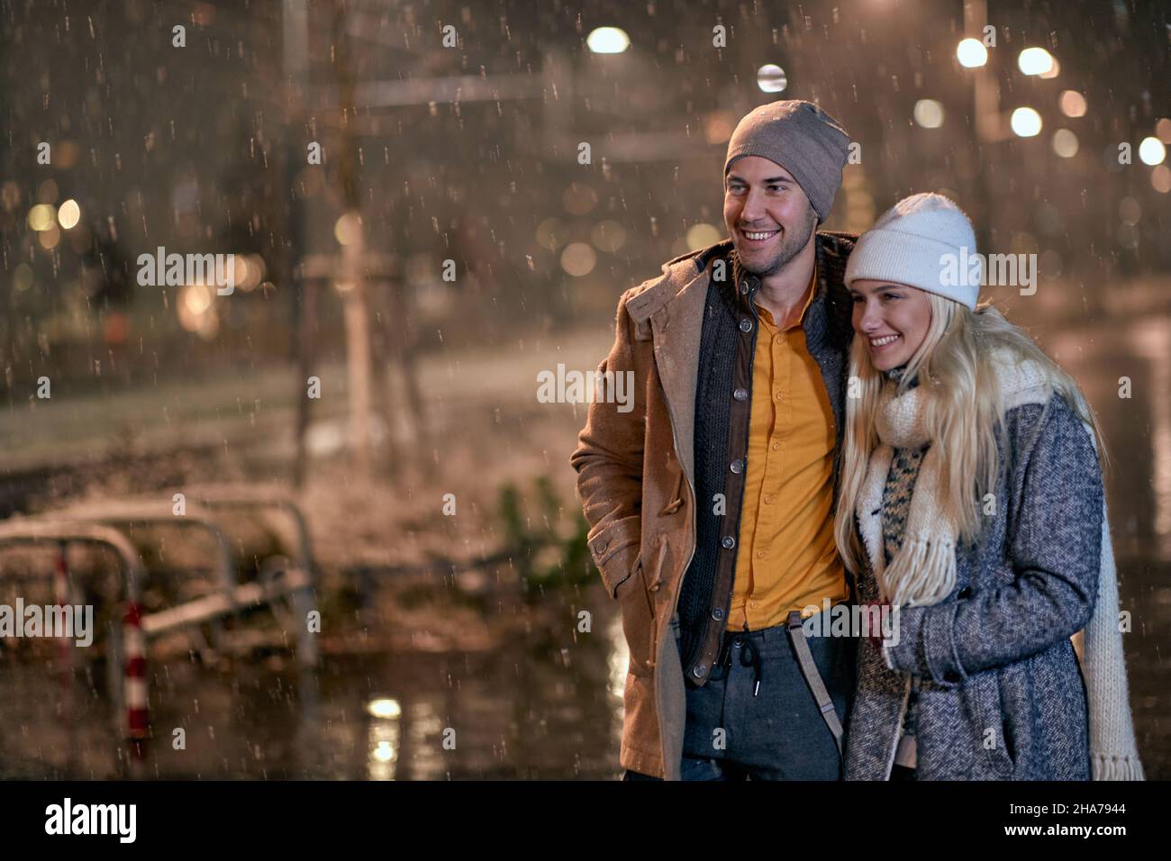 Happy couple at snowy night and walking the city street Stock Photo