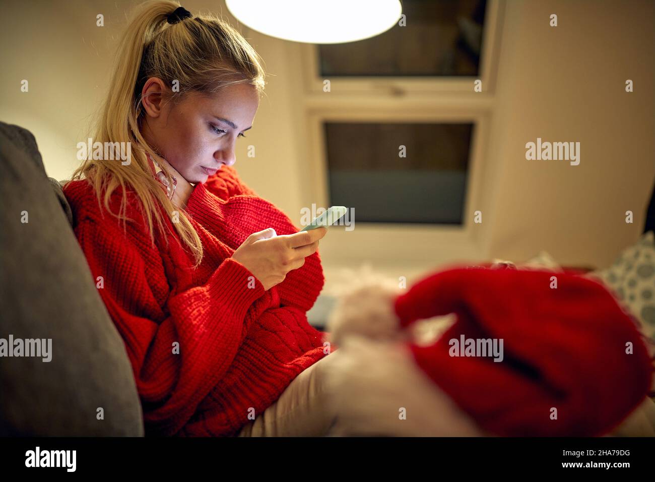 Young woman text messaging on smartphones on Christmas Stock Photo