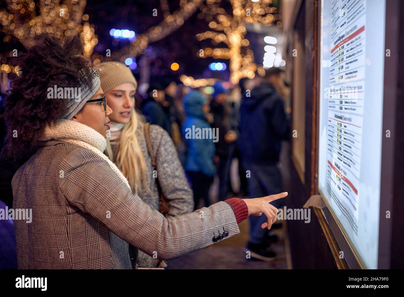 Christmas, winter holidays, vacation, travel- Happy Girls at festive street Stock Photo