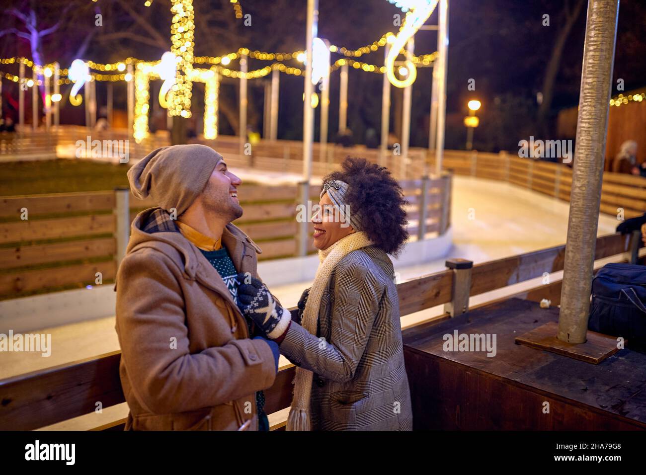 Happy couple in love on a christmas walk in the city evening, Stock Photo