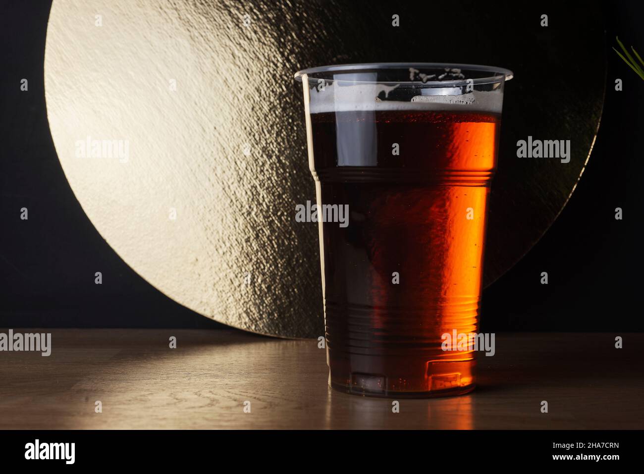 Plastic glass of IPA or APA craft beer or redale or lager in bar decoration. Stock Photo