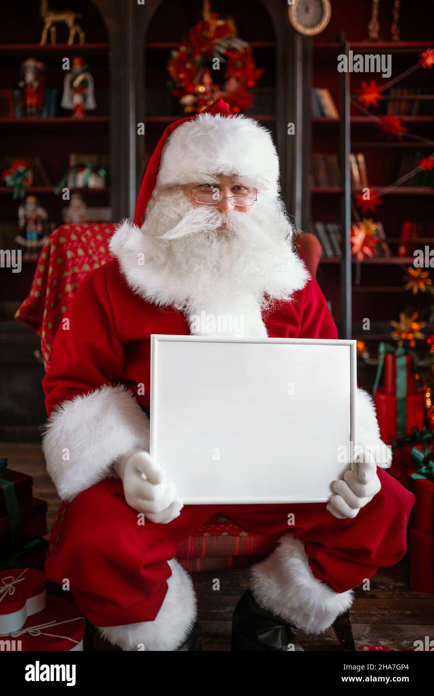 Santa Claus holding white frame in his hands Stock Photo