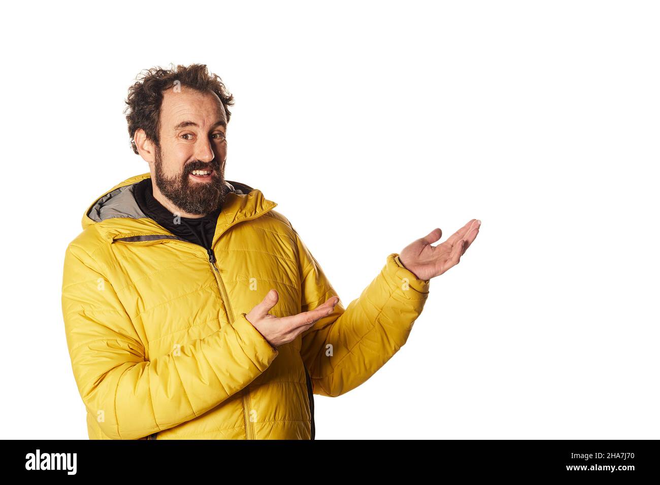 Young bearded male in yellow jacket showing a copy space Stock Photo