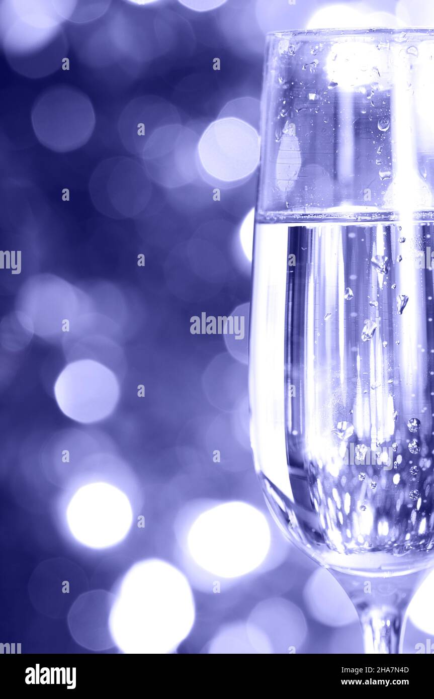 Champagne in glass at the christmas background. Close up. Color of 2022 year, very peri, toned Stock Photo