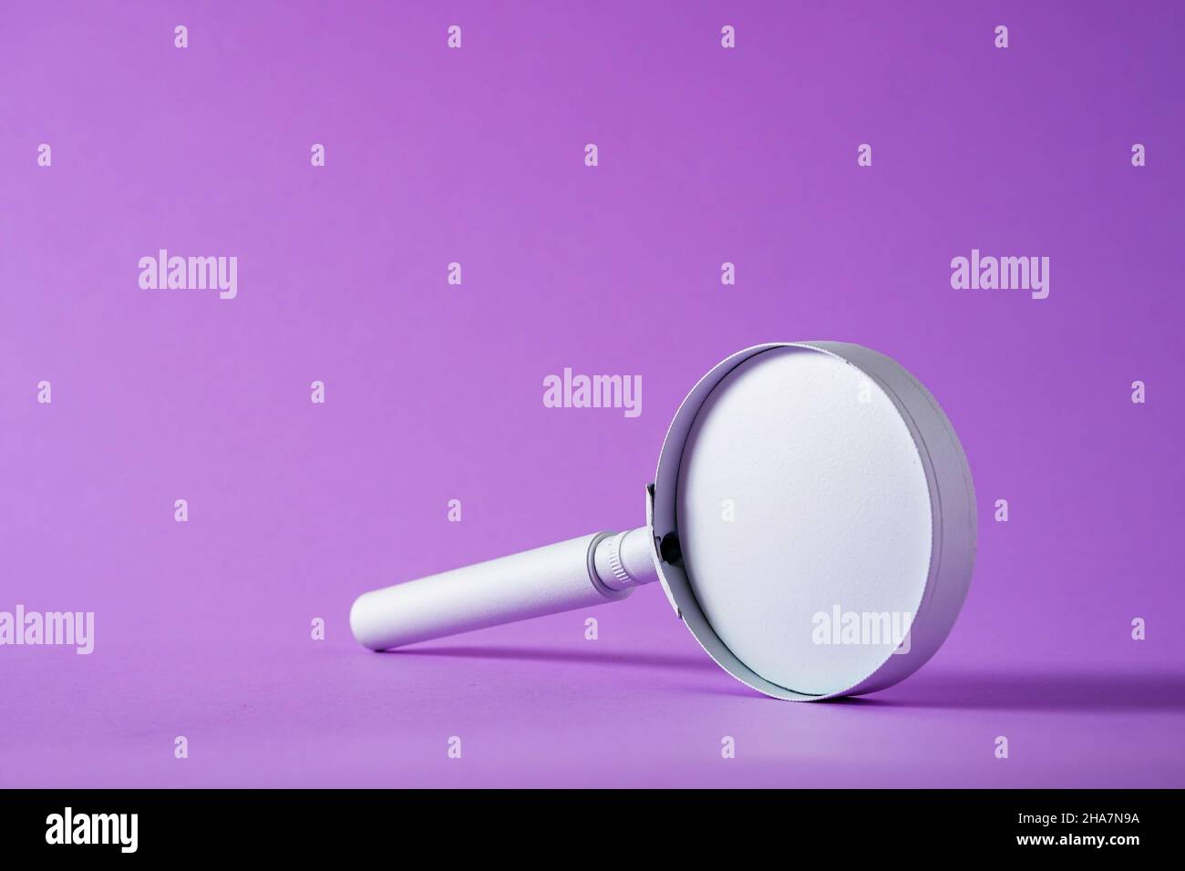 Small handheld magnifying glass balanced on edge over a graduated