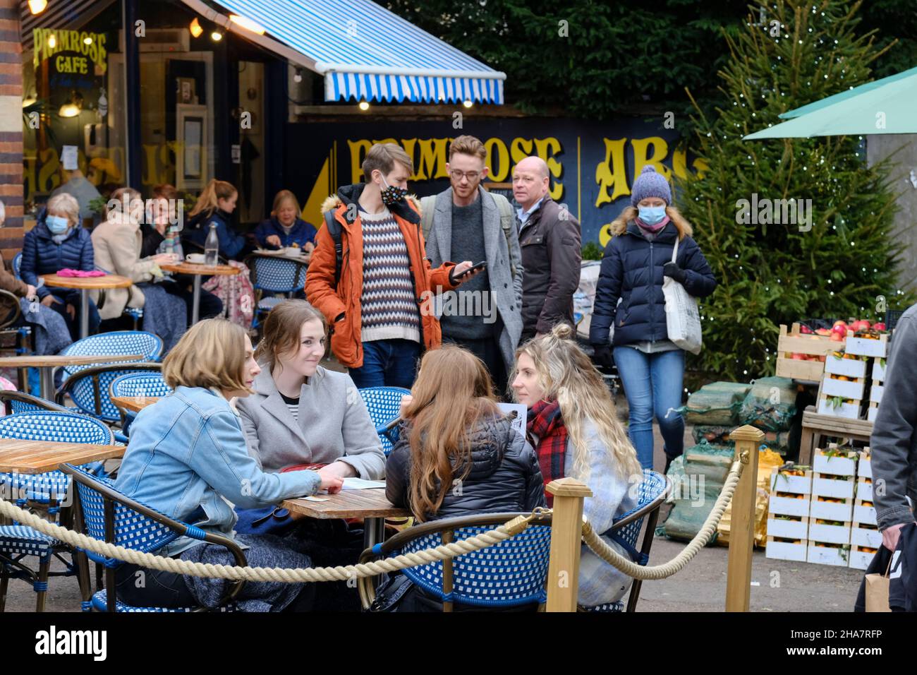 Clifton, Bristol, UK. 11th Dec, 2021. People do their Pre-Christmas shopping in up-market Clifton as concerns over the Omicron Covid-19 variant rise. Some people are wearing masks outside and some are not. Always time to stop at the Primrose Cafe. Credit: JMF News/Alamy Live News Stock Photo