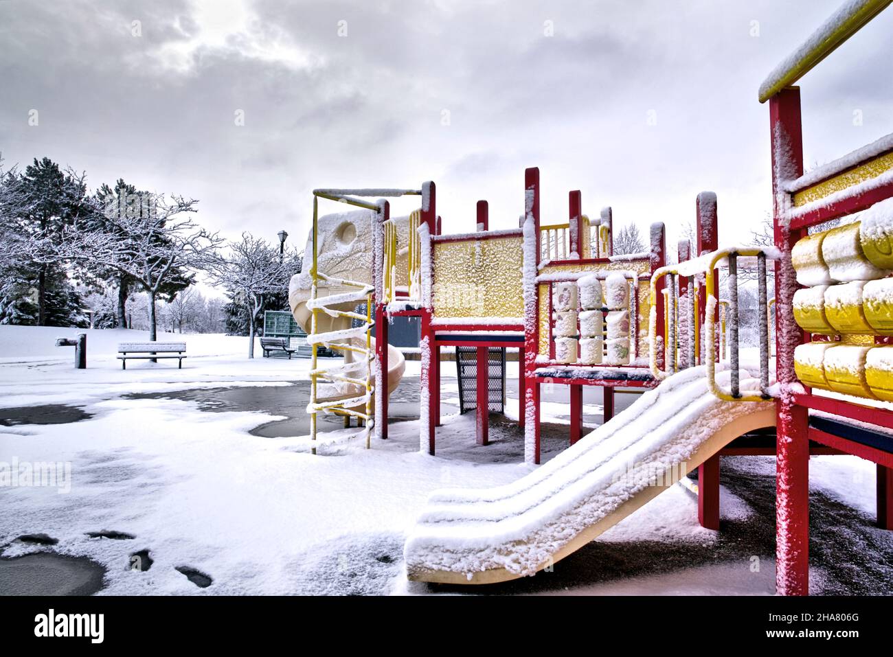 Slide and swing in the playground at the public park in winter Stock Photo