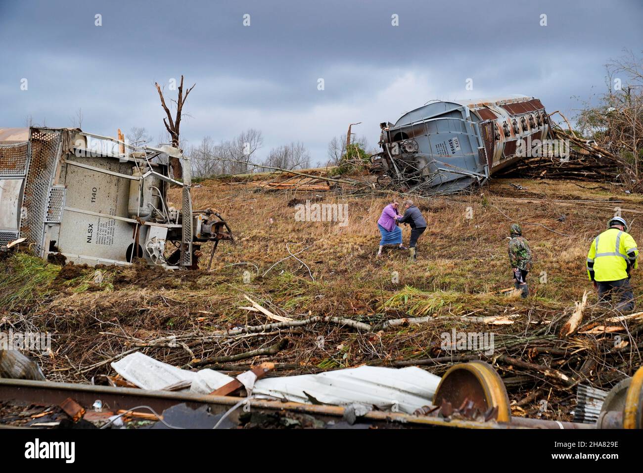 Local residents walk past the scene of a train derailment after a