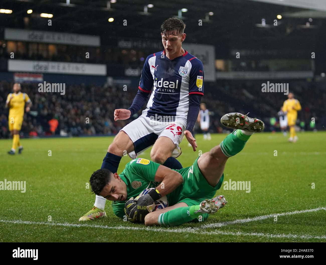 Reading goalkeeper Luke Southwood shields the ball under pressure from West Bromwich Albion's Taylor Gardner-Hickman during the Sky Bet Championship match at The Hawthorns, West Bromwich. Picture date: Saturday December 11, 2021. Stock Photo