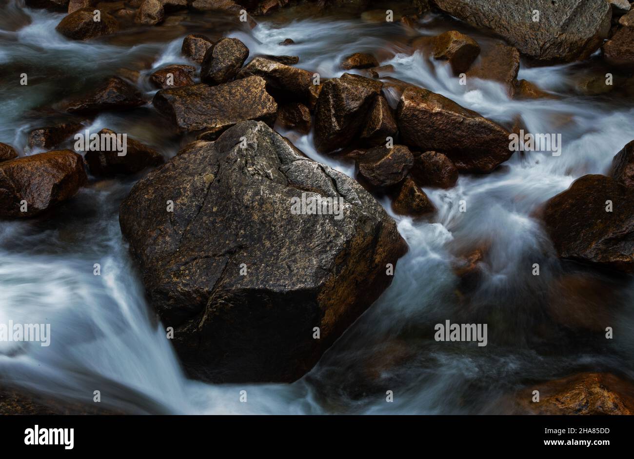 Long exposure of water stream and rocks Stock Photo