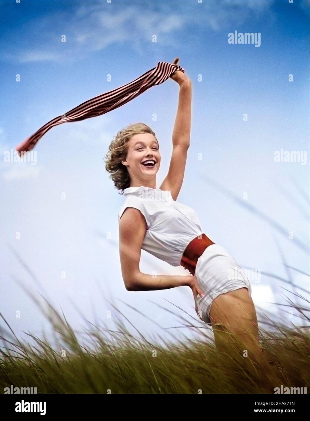 1950s 1960s SMILING YOUNG WOMAN IN WHITE SHORTS AND BLOUSE BENDING BACK WAVING SCARF IN THE WIND STANDING ON GRASSY BEACH DUNE - g5093c HAR001 HARS YOUNG ADULT PLEASED JOY LIFESTYLE SATISFACTION FEMALES GROWNUP HEALTHINESS COPY SPACE HALF-LENGTH LADIES PHYSICAL FITNESS PERSONS GROWN-UP CONFIDENCE SUMMERTIME FRESH SHORE BENDING HAPPINESS CHEERFUL ADVENTURE LEISURE SUMMER SEASON BREEZE DUNES EXCITEMENT RECREATION SQUINTING INTO UP BEACHES BLOUSE SMILES MOTION BLUR GRASSY JOYFUL SANDY STYLISH WINDY BREEZY RELAXATION SAND DUNE SEASON YOUNG ADULT WOMAN CAUCASIAN ETHNICITY HAR001 OLD FASHIONED Stock Photo