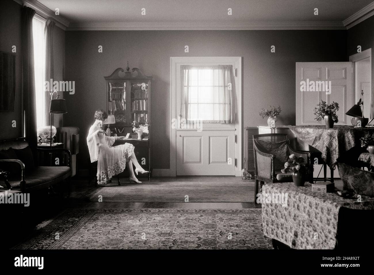 1920s ELEGANTLY DRESSED WOMAN SITTING AT DESK IN WELL-APPOINTED ROOM READING A LETTER MOODY DOOR LIGHT - i311 HAR001 HARS YOUNG ADULT WEALTHY MYSTERY RICH LIFESTYLE FEMALES FLORAL MOODY GROWNUP HOME LIFE LUXURY COPY SPACE FULL-LENGTH LADIES PERSONS QUIET GROWN-UP SUNLIGHT SERENITY B&W SADNESS DECORATION DECOR HAPPINESS LEISURE INTERIORS RELAXED PRIDE MOOD UPSCALE CONCEPTUAL AFFLUENT CHIPPENDALE ELEGANTLY HEM STYLISH ARCHITECTURAL DETAIL CORRESPONDENCE HOMEY RELAXATION WELL-TO-DO YOUNG ADULT WOMAN BLACK AND WHITE CAUCASIAN ETHNICITY FURNISHINGS HAR001 OLD FASHIONED Stock Photo