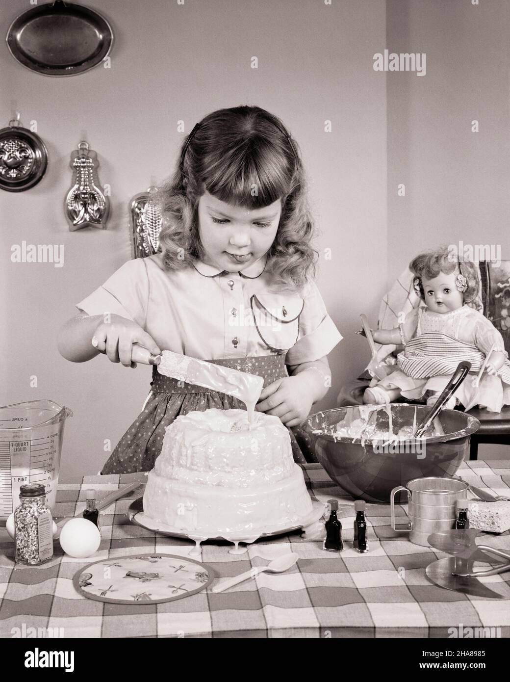 Icing Mess 1950s LITTLE GIRL MAKING A MESS IN KITCHEN PUTTING ICING ON A BUNT CAKE ...