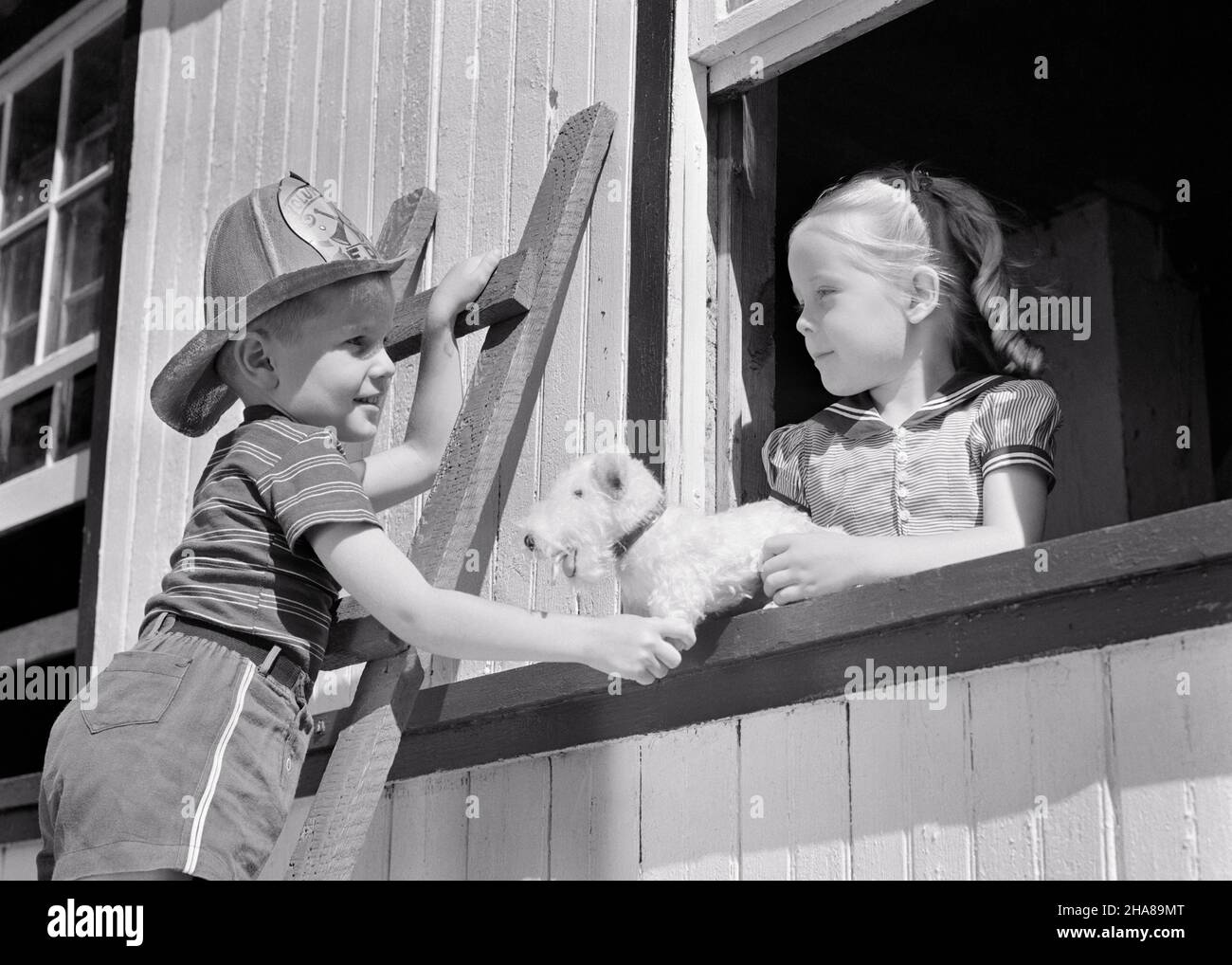 1930s 1940s BOY BROTHER ON LADDER WEARING TOY FIREMAN HAT PRETENDS TO RESCUE GIRL SISTER AND HER TOY STUFFED DOG FROM WINDOW - j6533 HAR001 HARS SAFETY JOY LIFESTYLE FEMALES BROTHERS JOBS RURAL STUFFED HOME LIFE COPY SPACE FRIENDSHIP HALF-LENGTH PERSONS INSPIRATION CARING MALES SIBLINGS CONFIDENCE FIREFIGHTER SISTERS B&W FIREMAN ADVENTURE PRETEND PROTECTION COURAGE AND EXCITEMENT LOW ANGLE OCCUPATIONS SIBLING CONNECTION FIREMEN ESCAPE FRIENDLY IMAGINATION FIREFIGHTERS FIRES HERO JUVENILES TOGETHERNESS BLACK AND WHITE CAUCASIAN ETHNICITY FIRE DEPARTMENT HAR001 OLD FASHIONED Stock Photo