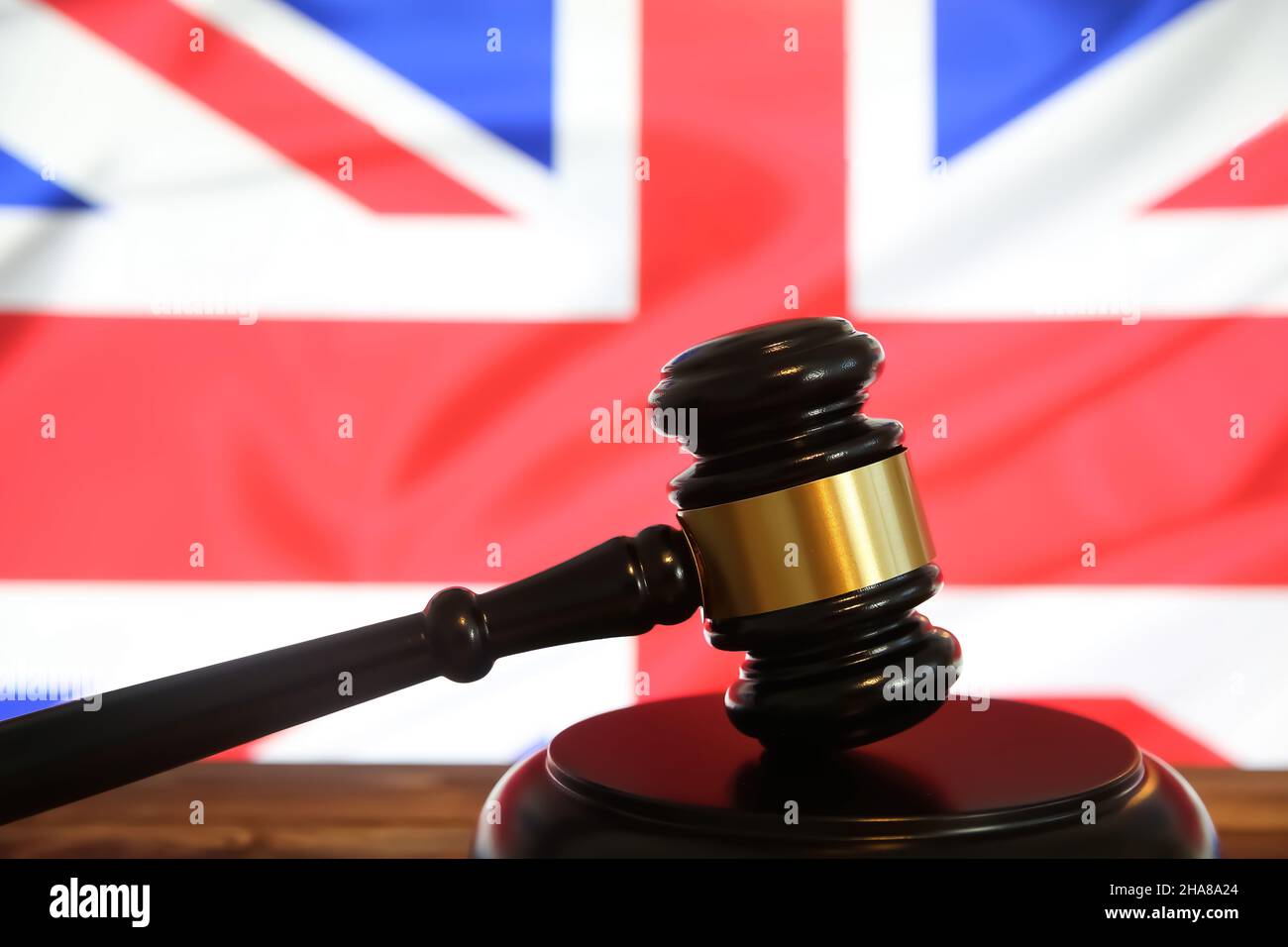 Closeup of isolated judge wood gavel with blurred english flag