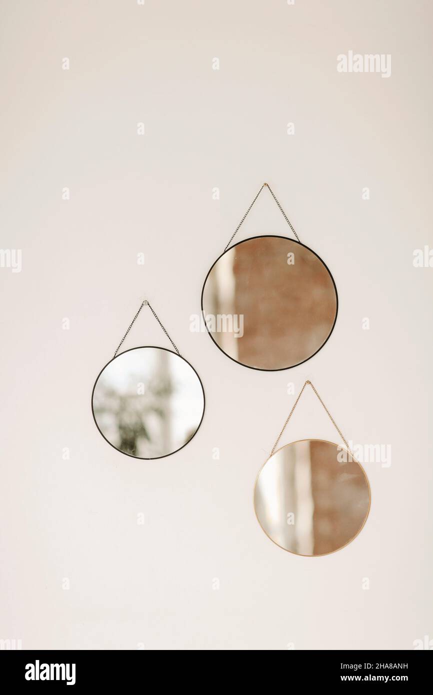 Close up photo of three round mirrors of different sizes hanging on